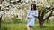 Pregnant woman resting in a flowering apple orchard