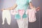 Pregnant woman with rope pins baby clothes