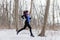 Pregnant woman running in winter during Pregnancy. Running sport woman. Female runner jogging in winter forest wearing