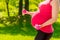 Pregnant woman`s belly closeup dumbbells