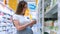 Pregnant woman shopping baby formula. Young pregnant woman buying infant baby formula milk on supermarket background