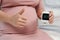 Pregnant woman showing thumb up and holding glucose meter with result of measurement sugar level. gestational diabetes concept