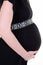 Pregnant woman side profile belly in dress black view in white background holding tummy with hands