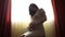 pregnant woman silhouette. pregnant a woman with big belly in her ninth month of pregnancy at home. expecting a newborn