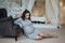 Pregnant woman sit near the armchair. Beautiful woman waiting for a baby. Elegant pregnant model at home