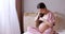 pregnant woman sitting on bed and combing long hair