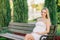 Pregnant woman sitting on bench outdoor looking to the camera