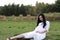 Pregnant woman sitting on grass lawn enjoy peaceful sunset sunrise time in nature Asian Chinese outdoor expecting her baby