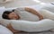 Pregnant woman sleeping with pregnancy pillow