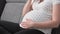 Pregnant woman on sofa with glass of milk