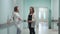 A pregnant woman standing in the corridor of the perinatal center communicates with a woman doctor in a white coat