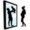 Pregnant woman is standing in front of a mirror. Girl sees in reflection a happy father with a baby in her hands. Family planning