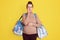 Pregnant woman standing isolated over yellow background ready to deliver going to hospital, being worried, looks scared, biting