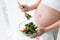 Pregnant woman starts to eat fresh salad