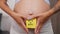 pregnant woman with a sticky note saying boy on her belly, closeup gender reveal concept