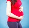 Pregnant woman with stomach pain touching her belly, aches in pregnancy and risk of miscarriage