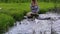 Pregnant woman on stone and let paper origami ship float water