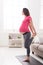 Pregnant woman stretching legs training indoors