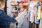 Pregnant woman in striped tunic communicates with seller in clothing store