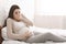 Pregnant woman suffering from morning nausea in bed