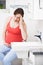 Pregnant Woman Suffering With Morning Sickness In Bathroom