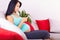 Pregnant woman surfing the web on smart phone at home