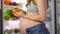 A pregnant woman takes tomatoes and salad from the refrigerator. Prepares food at home in the kitchen from Vegetables