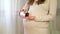 A pregnant woman takes a transparent round pill in a brown glass. Pregnancy vitamins in hand. Take care and health
