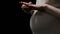 Pregnant woman taking off wedding ring, facing single motherhood, closeup