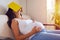 Pregnant woman tired of reading, sleeping on sofa with a book on