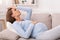 Pregnant Woman Touching Forehead Having Migraine Lying On Sofa