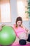 Pregnant woman touching her belly next to exercise ball