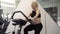 Pregnant Woman training exercise bike in gym Cardio exercises on Running simulator