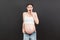 Pregnant woman in unzipped jeans showing her abdomen at colorful background with copy space