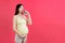 Pregnant woman using asthma inhaler during attack for being healthy at colorful background with copy space. Health care concept