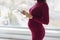 Pregnant woman using smart phone during pregnancy for shopping maternity clothes, using pregnancy app, doing health