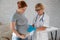 Pregnant woman visiting a doctor. Elderly Caucasian female gynecologist holds hands on the tummy of a pregnant patient.