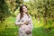 Pregnant woman walks alone in a meadow and drinks juice