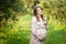 Pregnant woman walks alone in a meadow and drinks juice