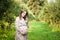 Pregnant woman walks alone in a meadow and drinks juice
