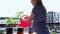 Pregnant woman water plants flowers with watering can in balcony