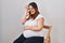 Pregnant woman wearing band aid for vaccine injection smiling happy doing ok sign with hand on eye looking through fingers