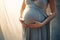 Pregnant woman wearing beautiful dress holding her hands on belly on a light background. Pregnancy, maternity, preparation and