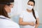 Pregnant woman wearing mask during medical consultation