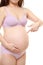 Pregnant woman wearing purple underwear pointing to her stomach