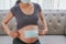 A pregnant woman wears a surgical mask to protect a COVID-19 Coronavirus and PM 2.5 and show a surgical mask on the abdomen to