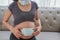 A pregnant woman wears a surgical mask to protect a COVID-19 Coronavirus and PM 2.5 and show a surgical mask on the abdomen to