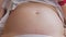 Pregnant womans belly with baby moving and kicking inside