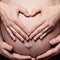 Pregnant Womans Belly with Hands Making a Heart