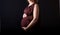 Pregnant women belly dressed in red blouse